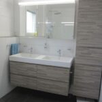 Ratgeber : Bad Oder Kuche Zuerst Renovieren Badezimmer Doppelwaschtisch Holzdekor Hochschrank Weisse Wandfliesen Dunkle Bodenfliesen Bad Oder Küche Zuerst Renovieren?