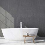 Ratgeber : Bad Oder Kuche Zuerst Renovieren Badezimmer Freistehende Badewanne Graue Betonwand Holzhocker Lichtschatten Bad Oder Küche Zuerst Renovieren?