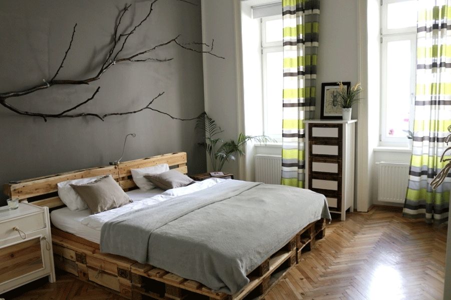schlafzimmer graue wandfarbe palettenbett fischgraetparkett gestreifte vorhaenge
