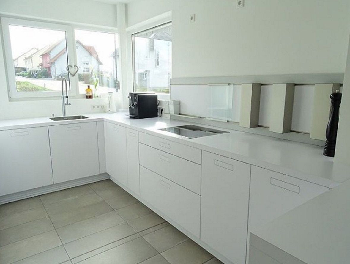 weisse kueche grifflose fronten weisse arbeitsplatte eckfenster schienensystem rueckwand