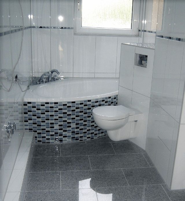 badezimmer weisse fliesen mosaik eckbadewanne graue bodenfliesen haengendes wc