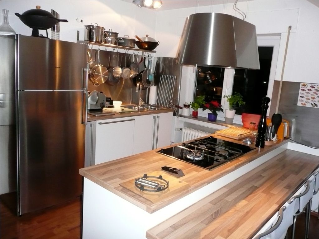 kueche mit edelstahlkuehlschrank und holzarbeitsplatte