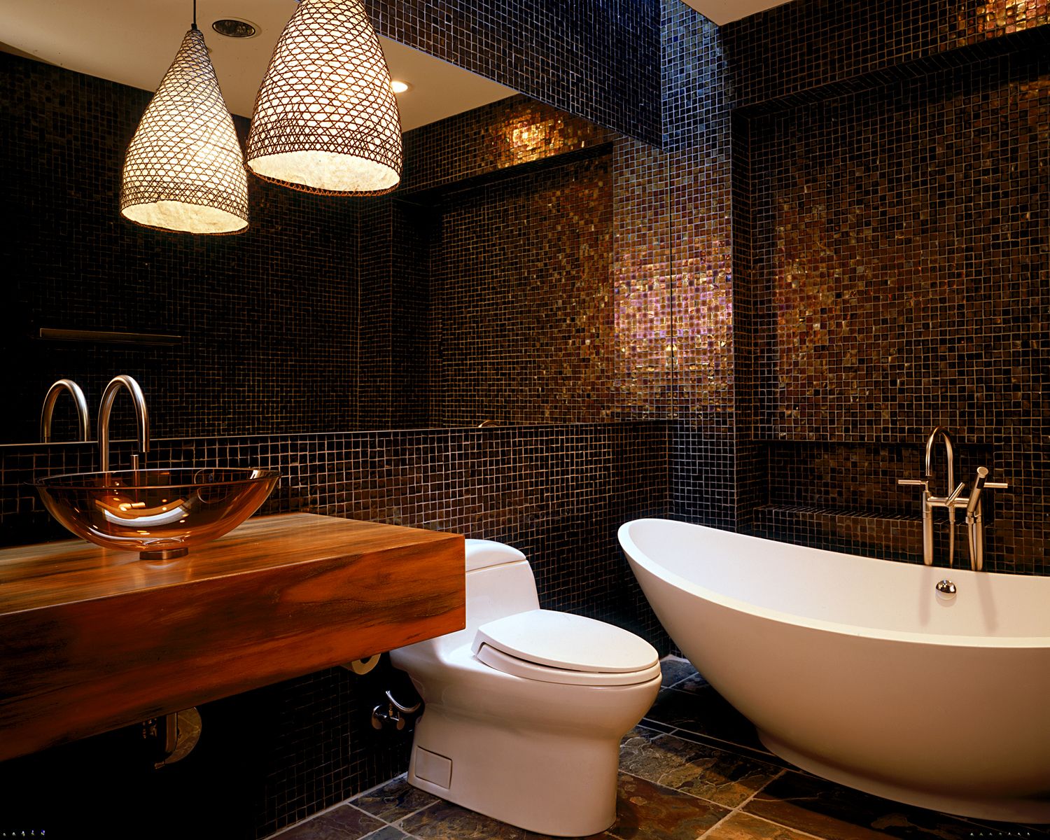 dunkles badezimmer mit mosaikfliesen und freistehender badewanne