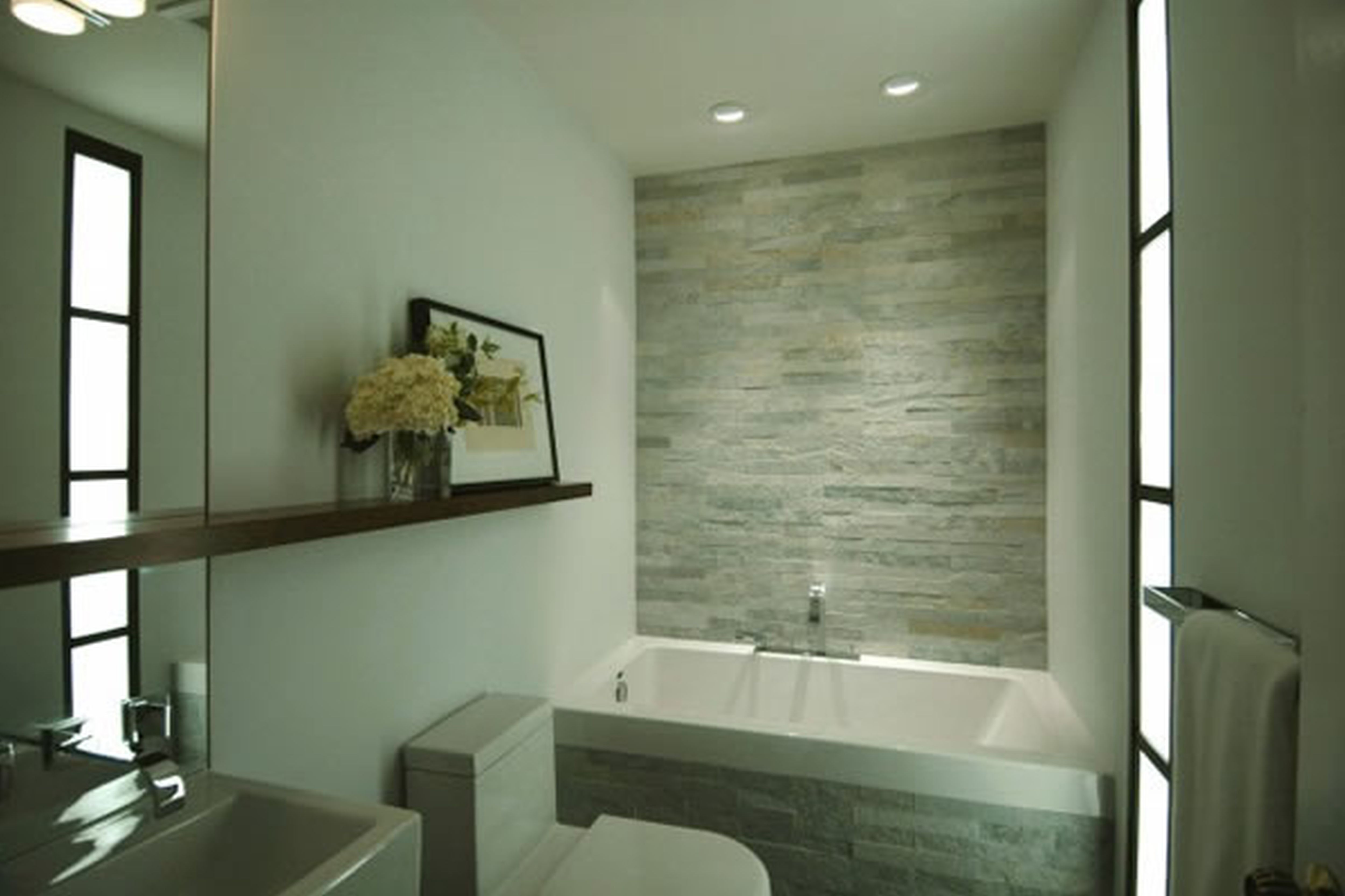 modernes badezimmer mit steinwand und rechteckiger badewanne