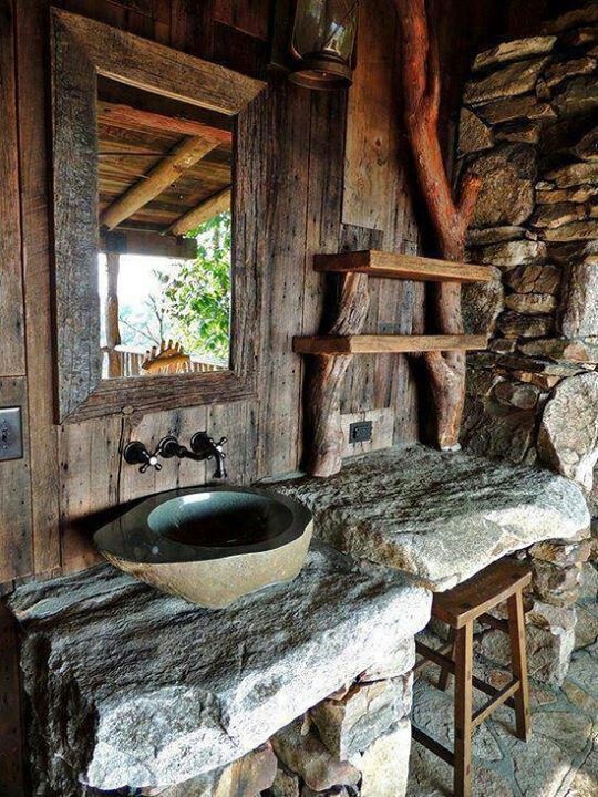 rustikales badezimmer mit natursteinwaschtisch und holzwand
