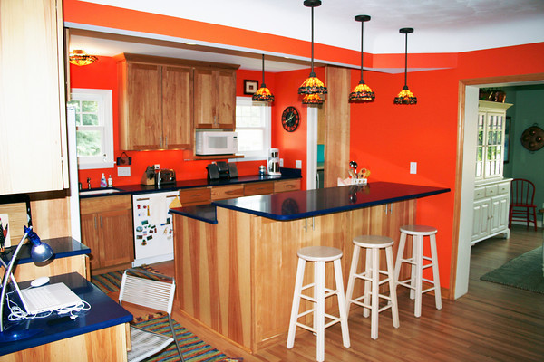 kueche mit orangefarbenen waenden und blauer arbeitsplatte