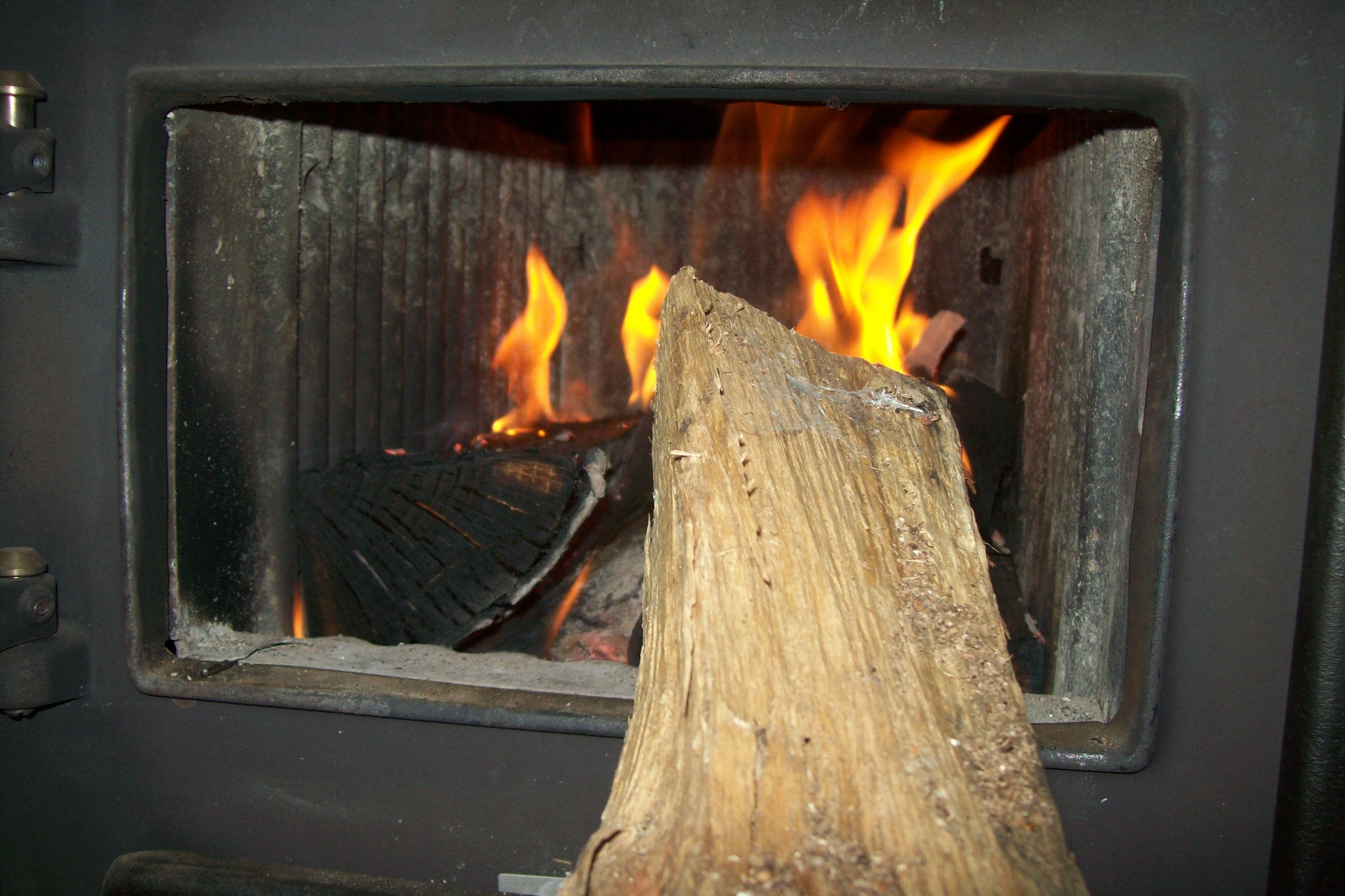 holzofen brennendes feuer holzscheit ofenklappe