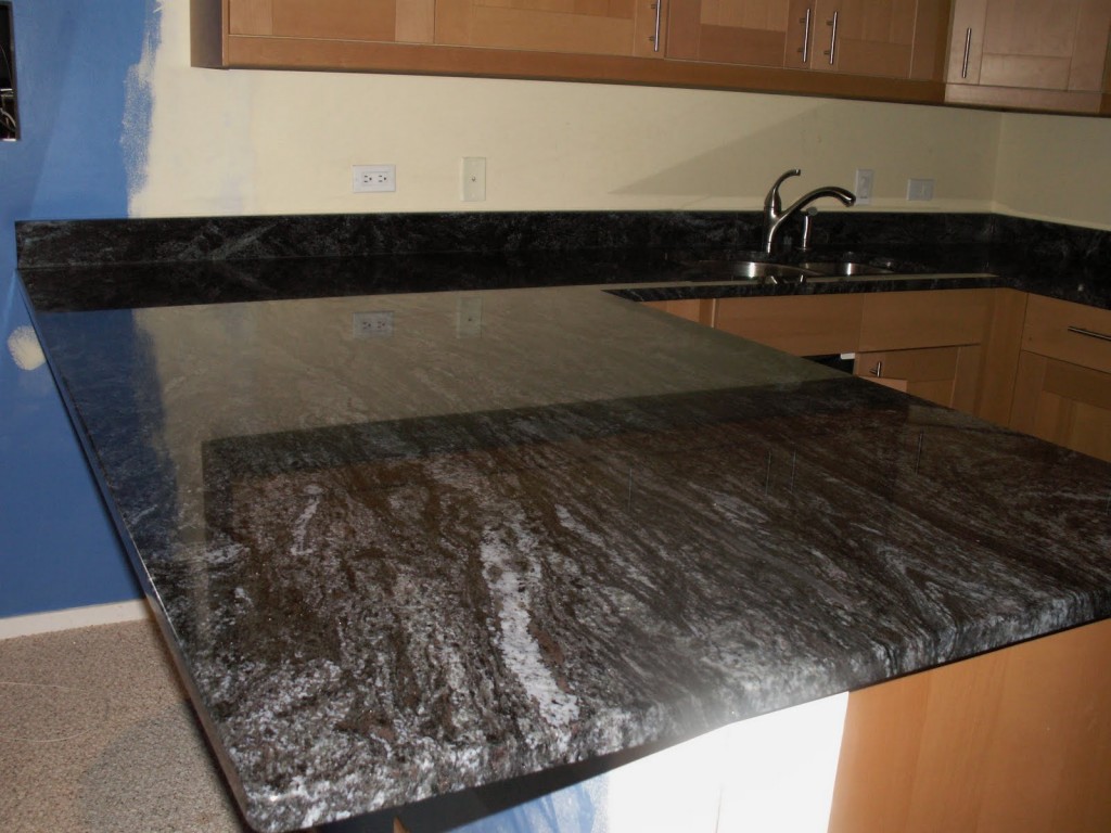 dunkle granitarbeitsplatte kuchenzeile holzschranke blaue wand