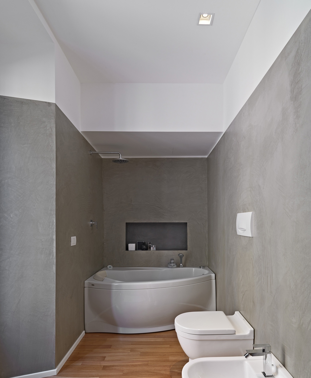 wellness bad graues badezimmer mit eckbadewanne und holzboden